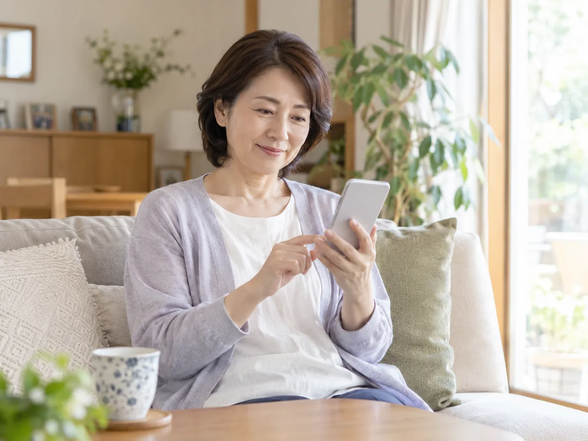 自宅でスマートフォンの報告を確認するご家族